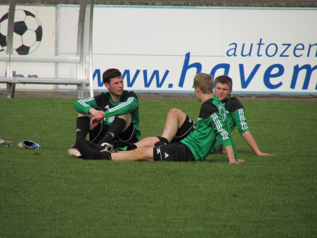 Simon Klepatz, Jan Rogge und Jannik Preuß tauschen sich nach dem Spiel im Sitzen auf dem Spielfeld aus